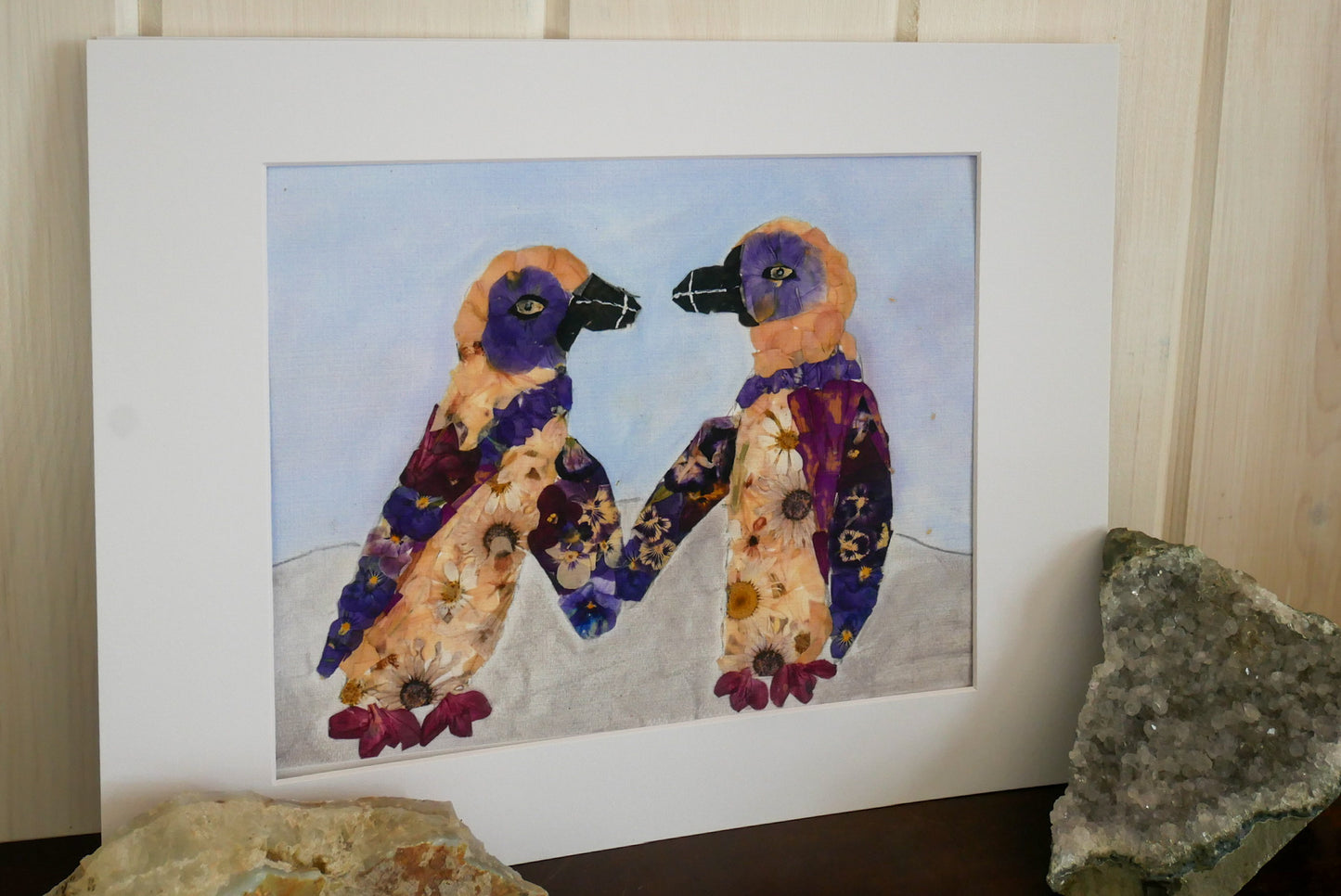two colorful birds, possibly penguins, standing together in a frame.