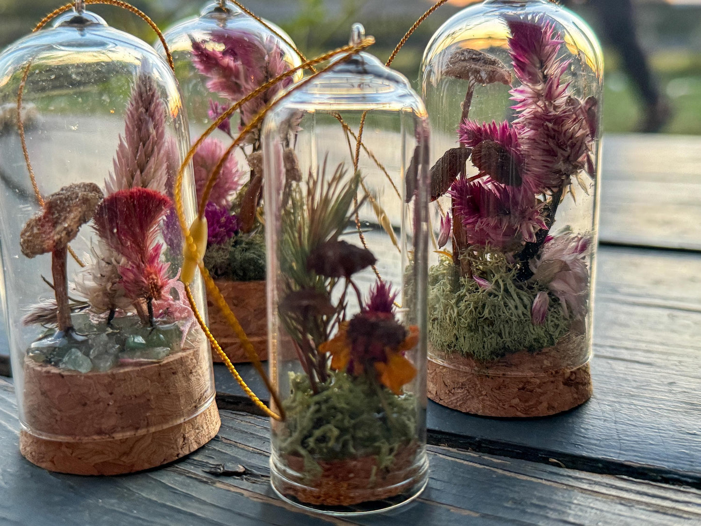 tiny mushroom and moss and dried flower in a glass cloche ornament