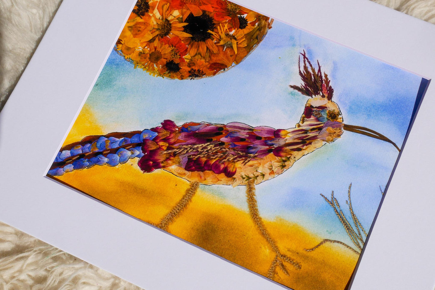 The image is a vibrant painting depicting a colorful bird with a long beak, set against a backdrop of a sunflower and a blue sky.