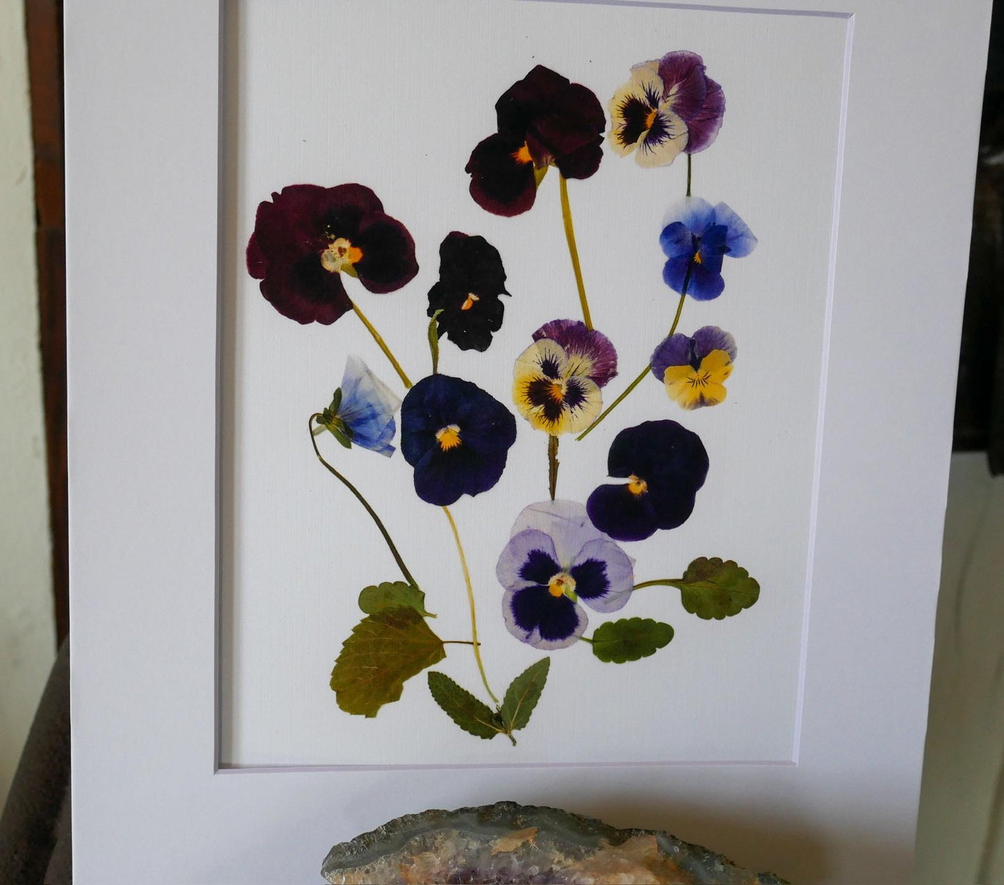 a framed print of a flower arrangement with various colored flowers, including purple, blue, and yellow ones.