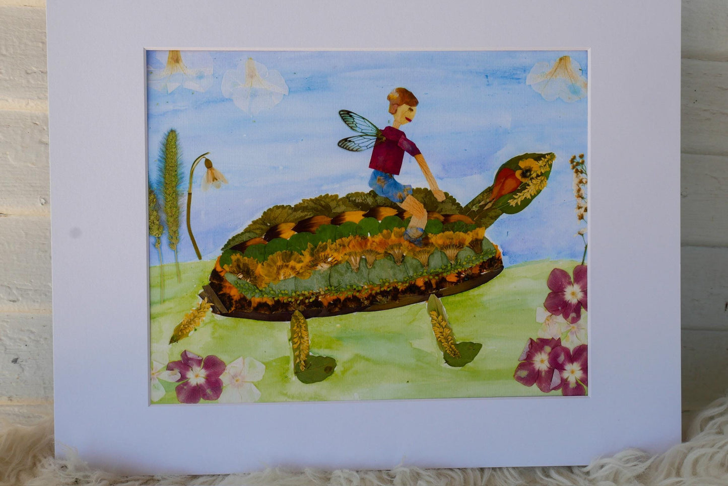 A painting depicting a person riding a turtle through a field with flowers and plants.
