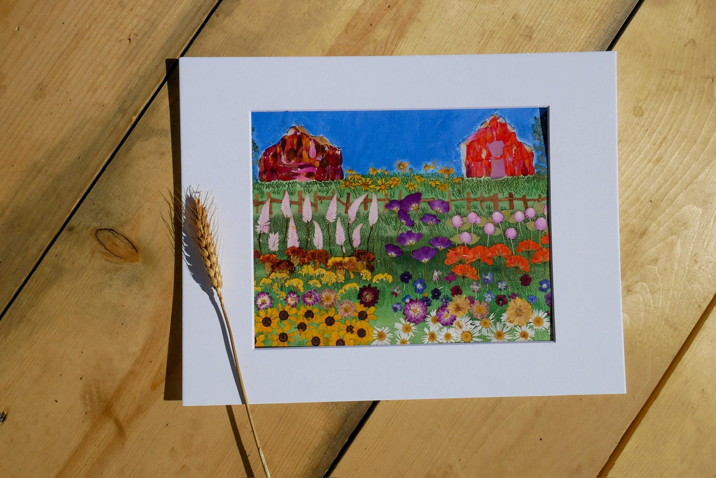 a vibrant painting of a colorful garden with flowers, barns, and a wooden fence, all set against a blue sky.