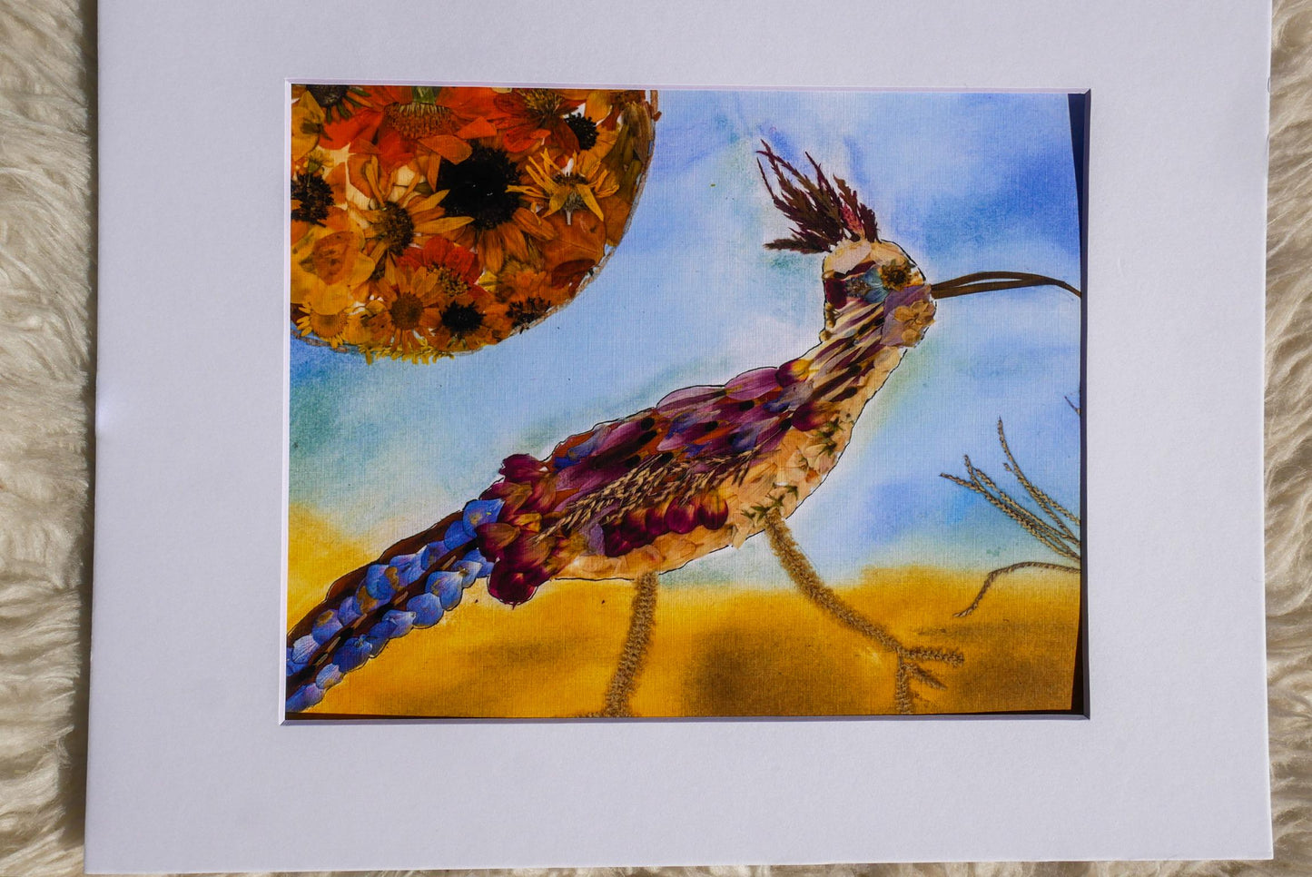 The image is a vibrant painting depicting a colorful bird with a long neck and tail, standing on a sandy beach against a backdrop of a clear blue sky.