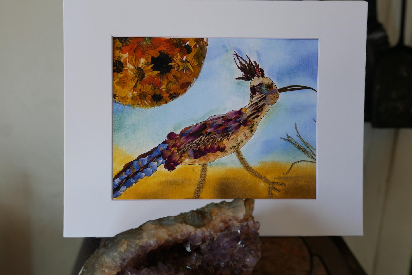 a vibrant painting of a colorful bird, possibly a roadrunner, set against a backdrop of a sunflower.