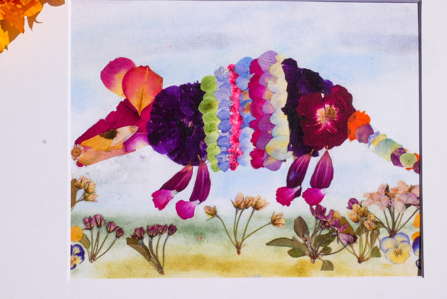 A vibrant collage of various colorful flowers and leaves, including roses, daisies, and other blooms, arranged in a visually striking manner.