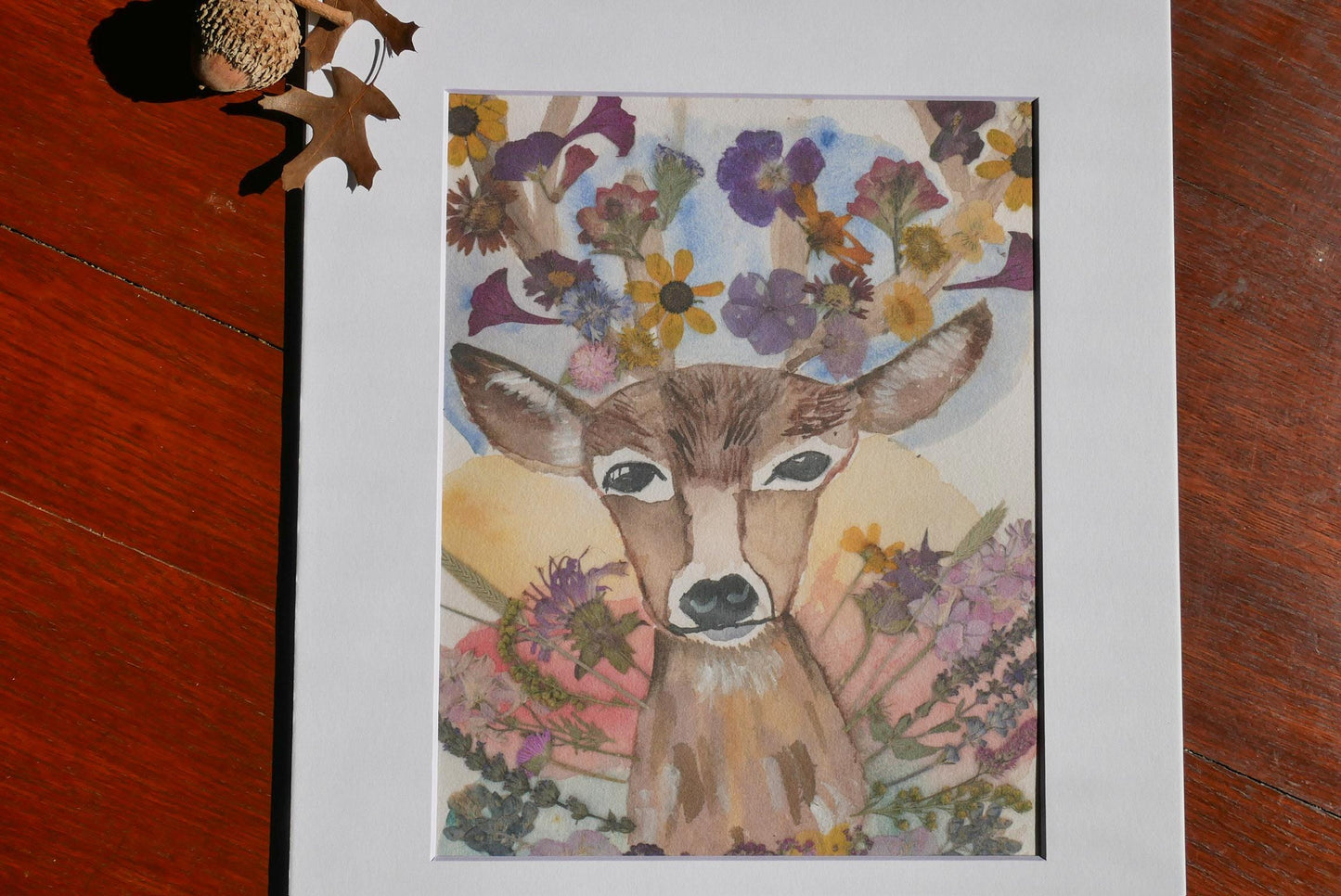 a deer with a flower crown on its head, surrounded by a colorful array of flowers.