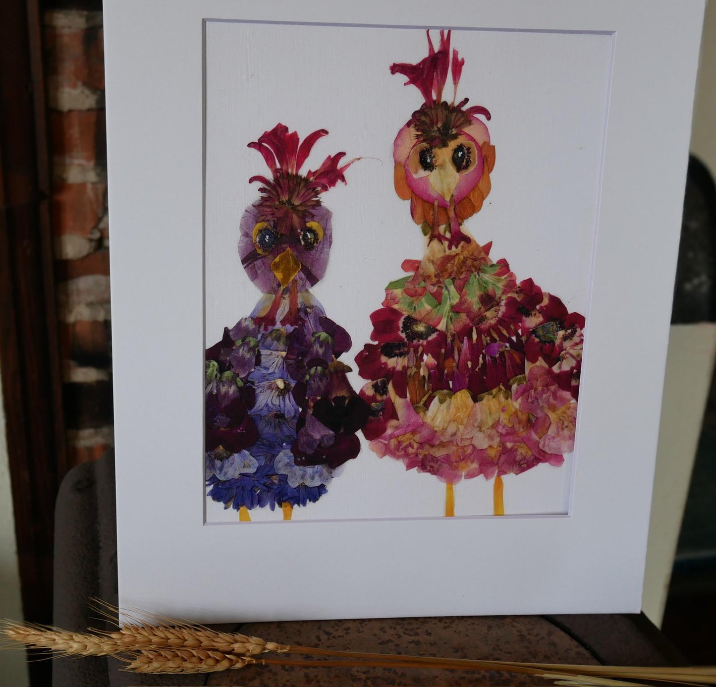 two vibrant, flower-like creatures with colorful feathers and petals, arranged in a frame.