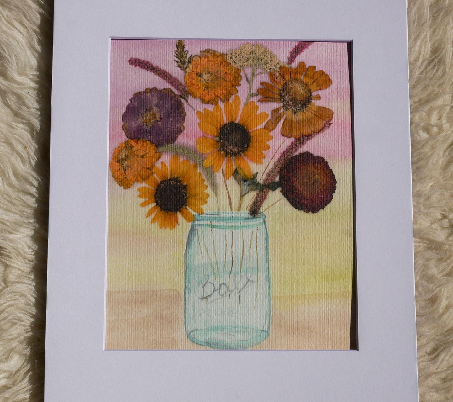 A framed painting depicting a glass jar filled with a variety of colorful flowers, including sunflowers and other blooms.