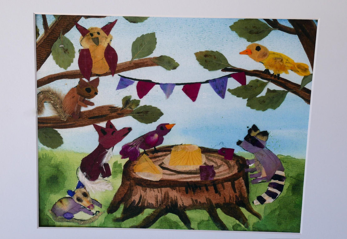 A collage of various animals, including a bird, squirrel, raccoon, and fox, gathered around a tree stump with a yellow object on it, set against a backdrop of leaves and a blue sky.
