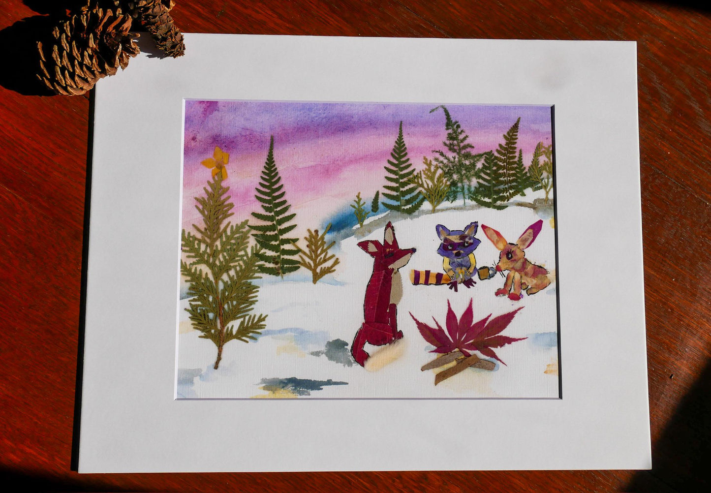 The image is a watercolor painting depicting a snowy forest scene with various animals, including a fox, a rabbit, and a bird.