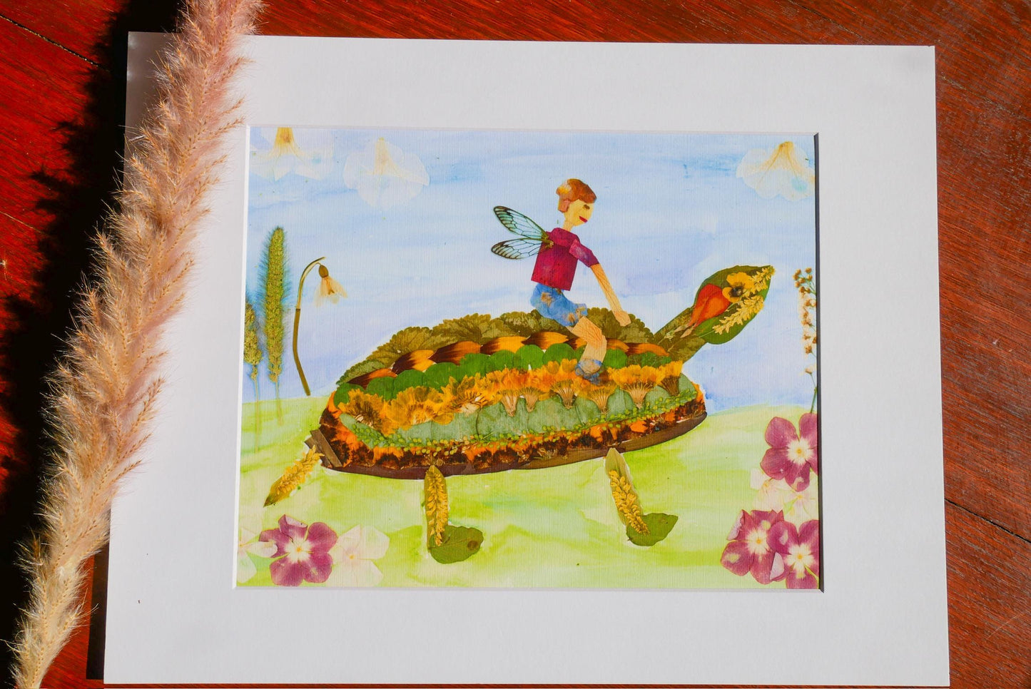 A painting of a person riding a turtle-shaped bird, with the turtle and bird being made of colorful materials and surrounded by flowers.